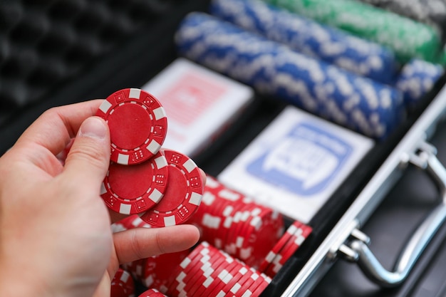 ręka mężczyzny sięga po żetony do pokera.