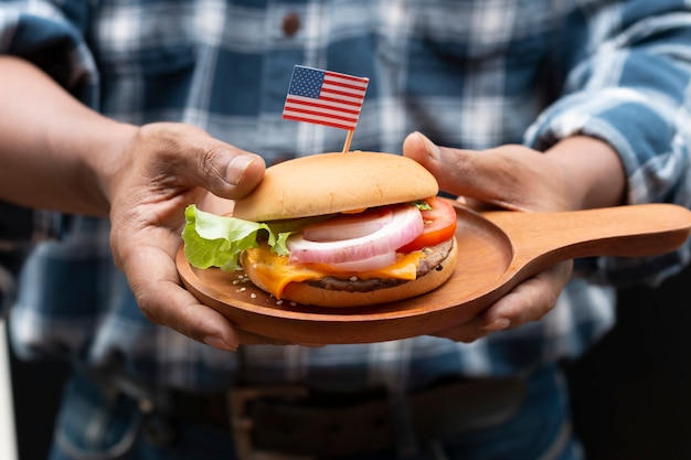 Ręka mężczyzny trzymającego amerykański domowy burger.