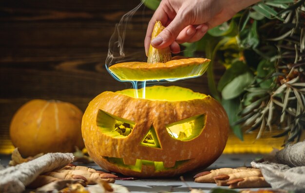 Ręka Otwiera Dynię Z Twarzą Wyciętą Na Halloween