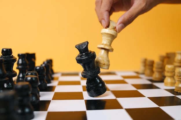 Ręka poruszająca figurę szachową w rozgrywce sukces gry Zarządzanie strategią lub koncepcja przywództwa