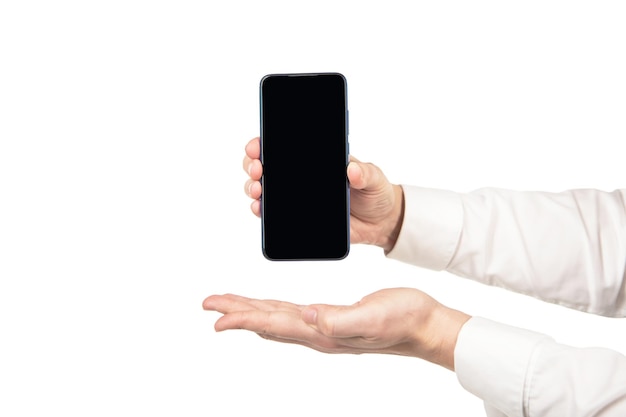 Ręka przedstawiająca smartfona z miejscem na ekran na białym tle reklamy