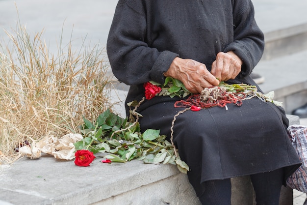 Ręka Stara Kobieta Robi Bukietowi Dla Sprzedawać Kwiaty Na Ulicie