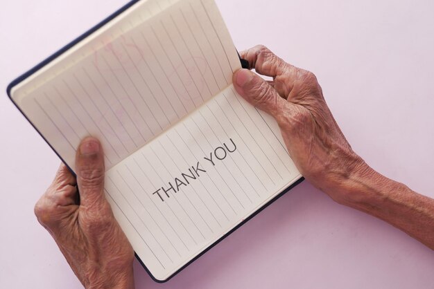 Ręka starszych kobiet trzyma podziękowania z góry na dół