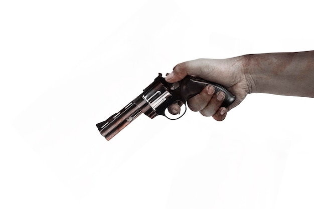 Ręka strasznego zombie z krwią i ranami niosącego pistolet jest odizolowana na białym tle
