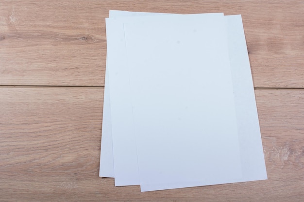 Zdjęcie ręka trzyma arkusze papieru na drewniane tła