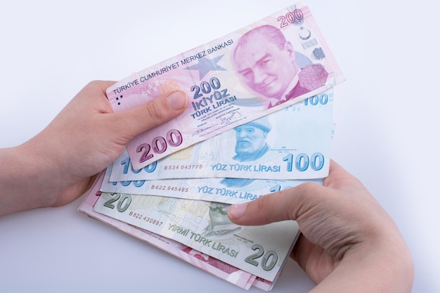 Ręka trzyma banknoty Lira turecka na białym tle