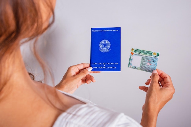 Zdjęcie ręka trzyma brazylijskie dokumenty prawa jazdy i pracy oraz karty ubezpieczenia społecznego
