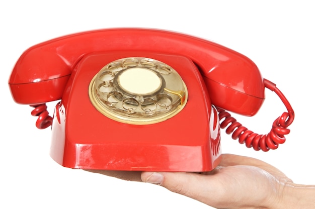 Ręka trzyma czerwony telefon na białym tle