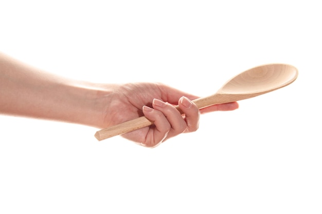 Ręka trzyma drewnianą łyżkę izolowany na białym tle