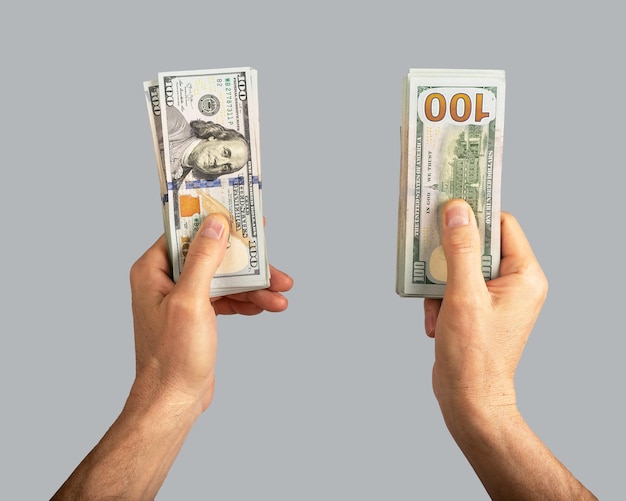 Ręka trzyma dwa banknoty stosy koncepcji pieniędzy dolara