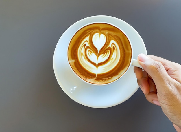 Ręka trzyma filiżankę kawy Latte Międzynarodowy dzień kawy