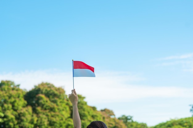 Ręka Trzyma Flagę Indonezji Na Tle Błękitnego Nieba Dzień Niepodległości Indonezji święto Narodowe I Szczęśliwe Koncepcje Uroczystości