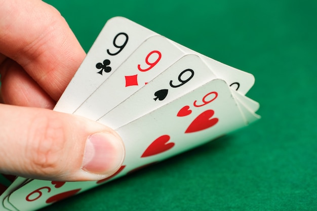 Ręka trzyma kombinację w pokerze - tego samego rodzaju na zielonym.