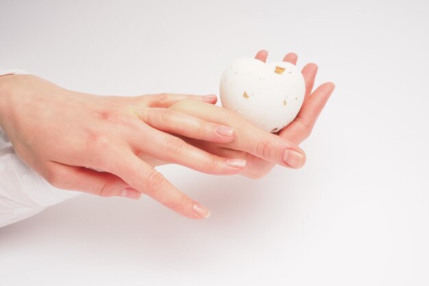 Ręka trzyma małe jajko z małą naklejką.