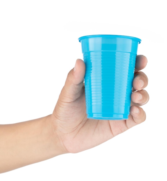 Ręka trzyma niebieskie plastikowe szkło na białym tle