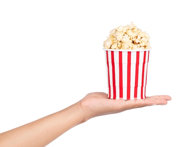 ręka trzyma Popcorn w paski wiadro na białym tle
