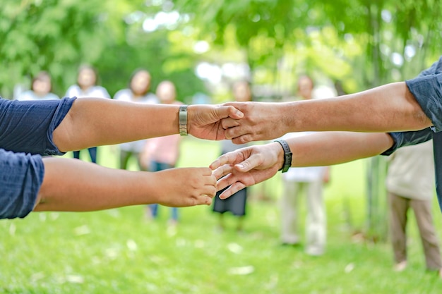 Zdjęcie ręka trzyma się razem w społeczności w parku ogrodowym