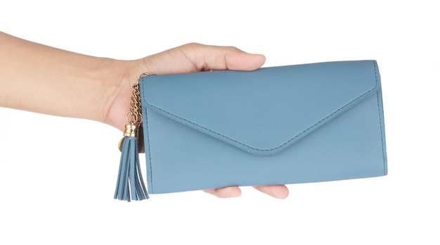 Ręka trzyma skórzaną niebieską torebkę portfelową na białym tle