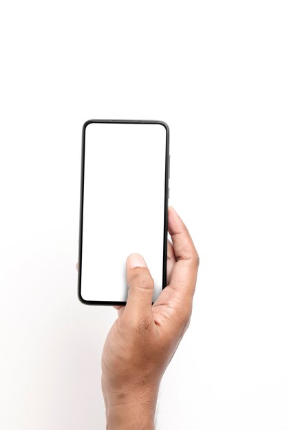 Ręka trzyma smartfon na białej powierzchni.