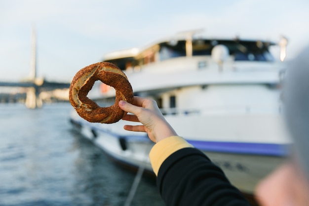 Ręka Trzyma Tradycyjnego Tureckiego Bajgiel Simit Błękitnego Bosphorus Zatoki Tło.