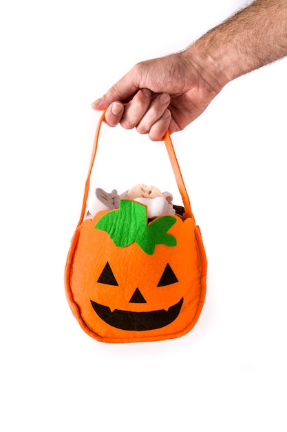 Zdjęcie ręka trzyma worek dyni halloween z cukierkami wewnątrz