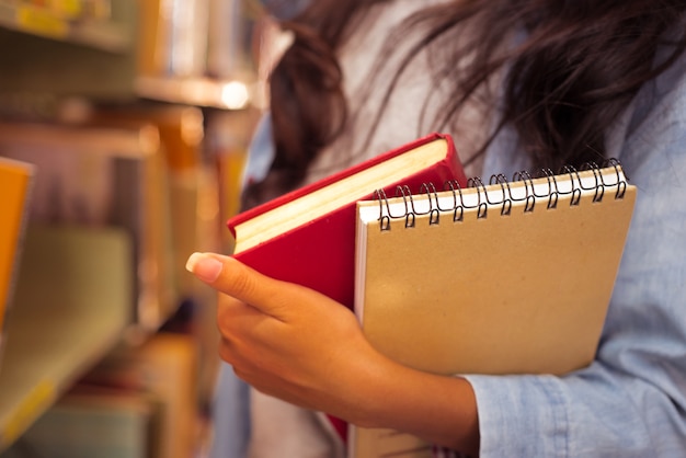 ręka trzymać książki studentów do czytania w bibliotece Uniwersytetu