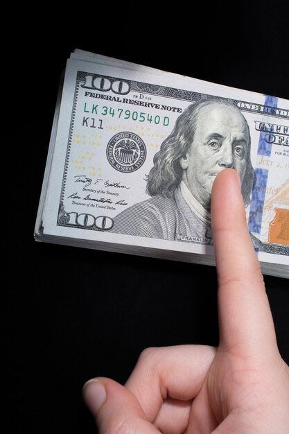 Ręka trzymająca banknoty amerykańskich dolarów na białym tle