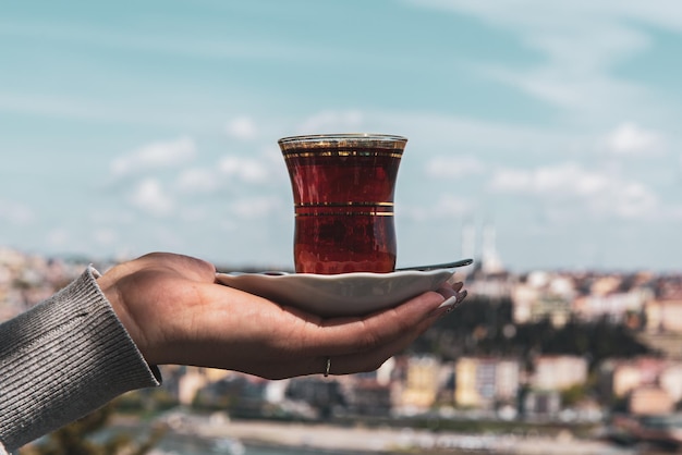 Ręka Trzymająca Filiżankę Tradycyjnej Tureckiej Herbaty Na Tle Stambułu, Turcja