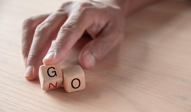 ręka trzymająca kości z tekstem do ilustracji słów GO lub NO