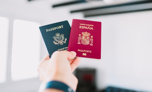 Ręka trzymająca paszporty europejskie i amerykańskie