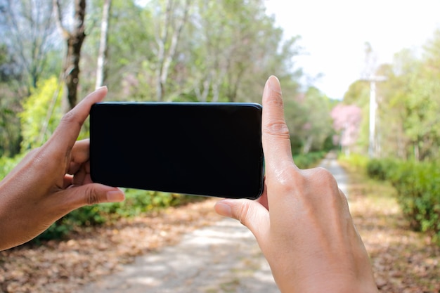 Zdjęcie ręka turystycznego mienia mobilny mądrze telefon bierze fotografię z wsi górą