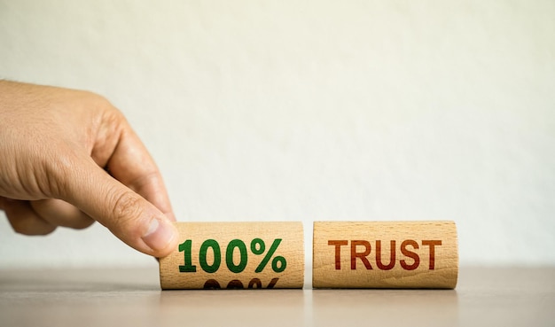Ręka układa drewniane klocki z napisem 100 procent zaufanie Zaufanie relacje między partnerami biznesowymi Szacunek i autorytet Zaufanie do osoby Rzetelność szczerość i kompetencje