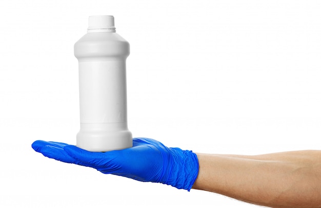 Ręka w niebieskiej rękawicy medycznej trzyma puszkę z pigułkami.