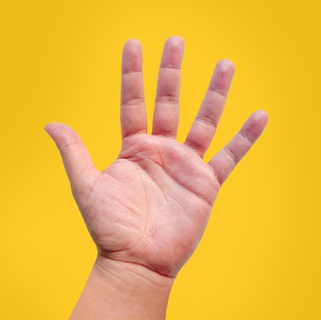 Zdjęcie ręka z pięcioma palcami odizolowana na żółtym tle