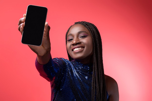 Reklama mobilna piękna czarna kobieta pokazująca smartfon z pustym ekranem przed kamerą