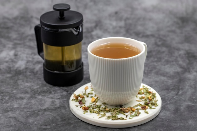 Relaksacyjna herbata ziołowa na ciemnym tle Herbatka ziołowa przygotowana z liści melisy kwiat jaśminu skórka jabłka pomarańcza drobinki cytryny i hibiskusa