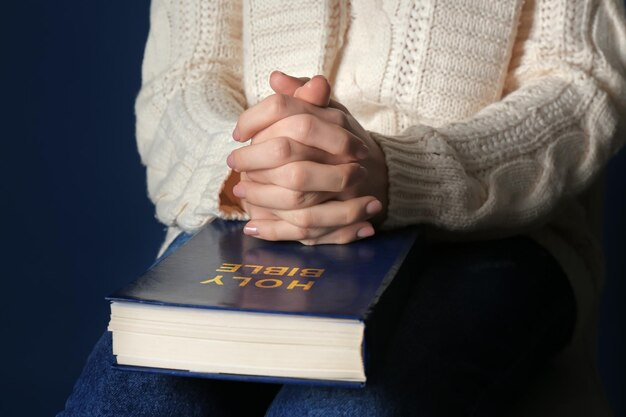 Religijna młoda kobieta modli się nad Biblią zbliżenie