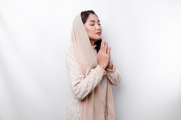 Religijna piękna azjatycka muzułmańska dziewczyna w chustce modlącej się do boga
