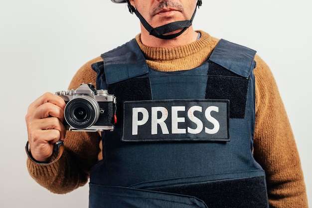 Reporter w kuloodpornej kamizelce z kamerą.
