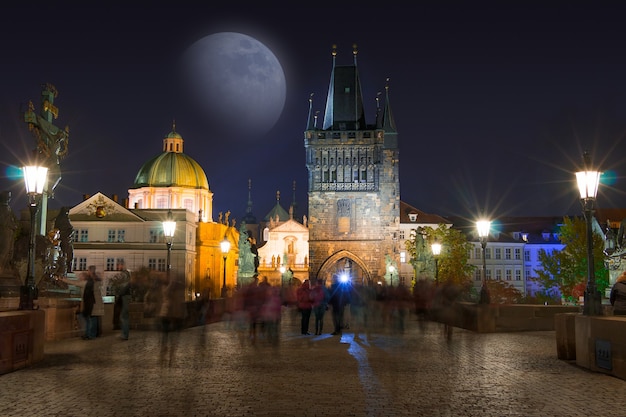Republika Czeska. Praga. Noc na moście Karola i księżycu. Wiele nierozpoznawalnych osób