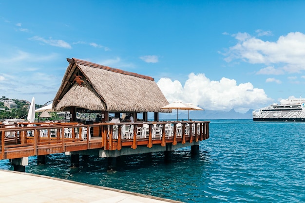 Restauracja nad oceanem w tropikalnym parku miejskim z palmami w Polinezji Francuskiej