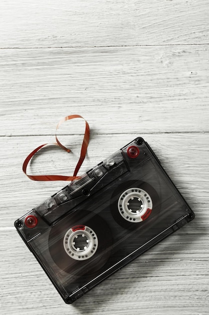 Retro kaseta audio z taśmą w kształcie serca na drewnianym tle