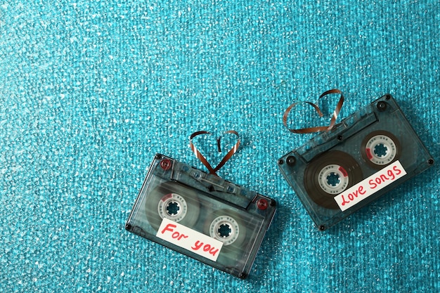 Retro kasety audio z taśmami w kształcie serc na niebieskim tle z teksturą