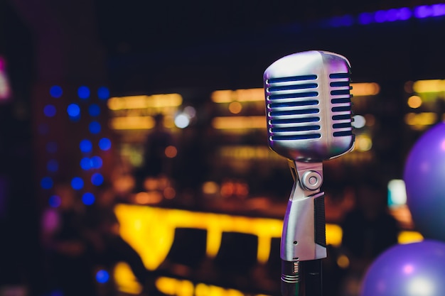 Zdjęcie retro mikrofon przeciw plamy kolorowej lekkiej restauraci