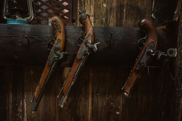 Zdjęcie retro, zabytkowe muszkiety pistoletowe wiszące na ścianie