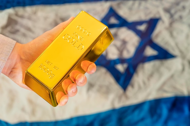 Rezerwa Złota Izraelskiej Koncepcji Złota Sztabka W Ręku Na Tle Flagi Izraelskiej