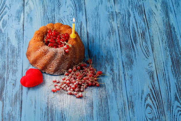 Zdjęcie ringowe ciasta z czerwonymi jagodami na drewnianej powierzchni