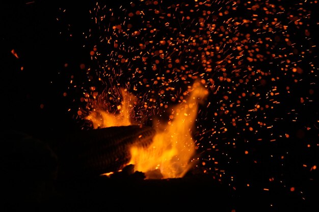 Roaster kukurydziany błyszczący ogień podczas gotowania na wybrzeżu plaży Marina Chennai India w nocy