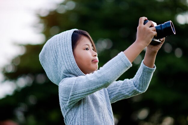 Rób zdjęcia aparatem bezlusterkowym. Mała dziewczynka mało ćwiczy fotografię przyrody