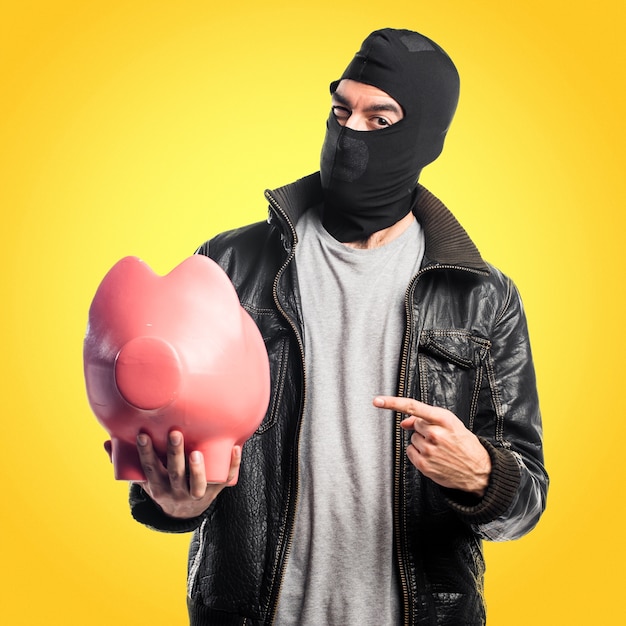 Robber Trzyma Piggybank Na Kolorowym Tle